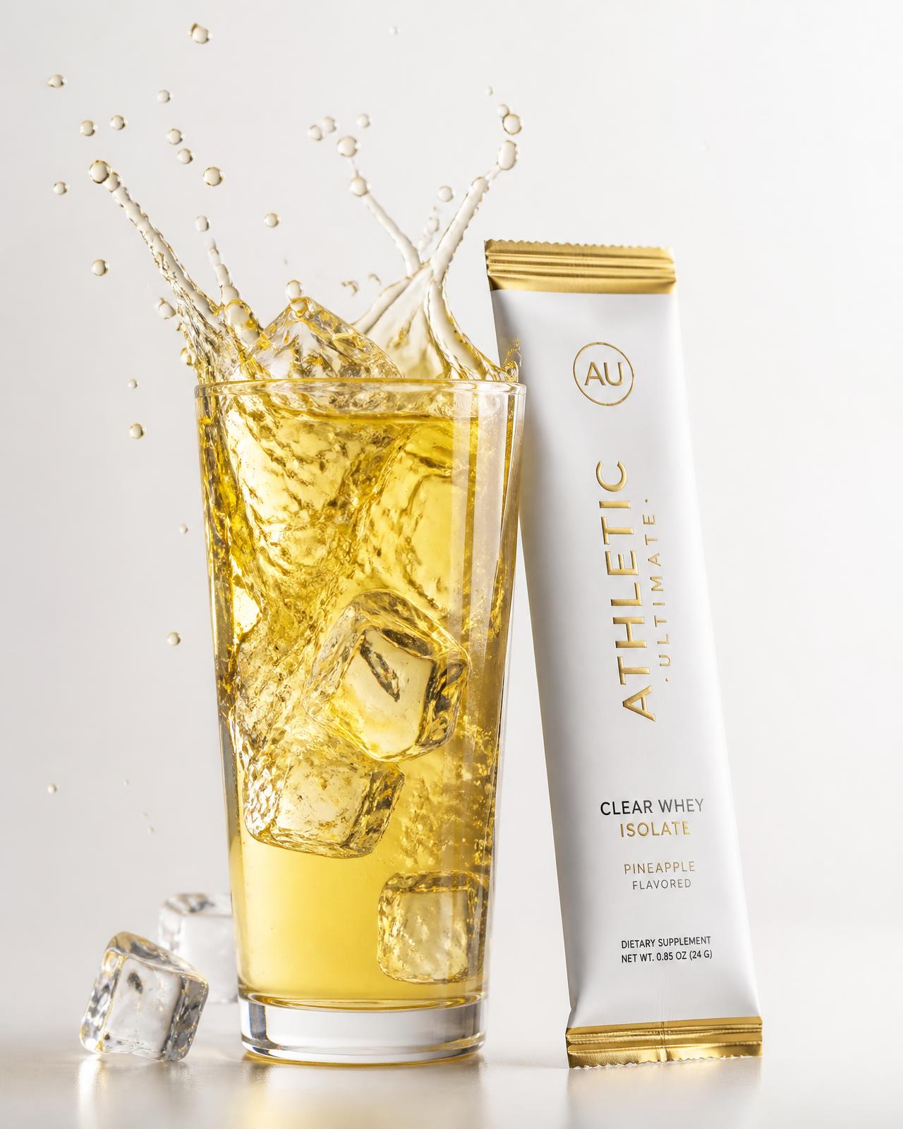 Crystal clear SipWhey protein drink over ice beside a gold foil sachet
